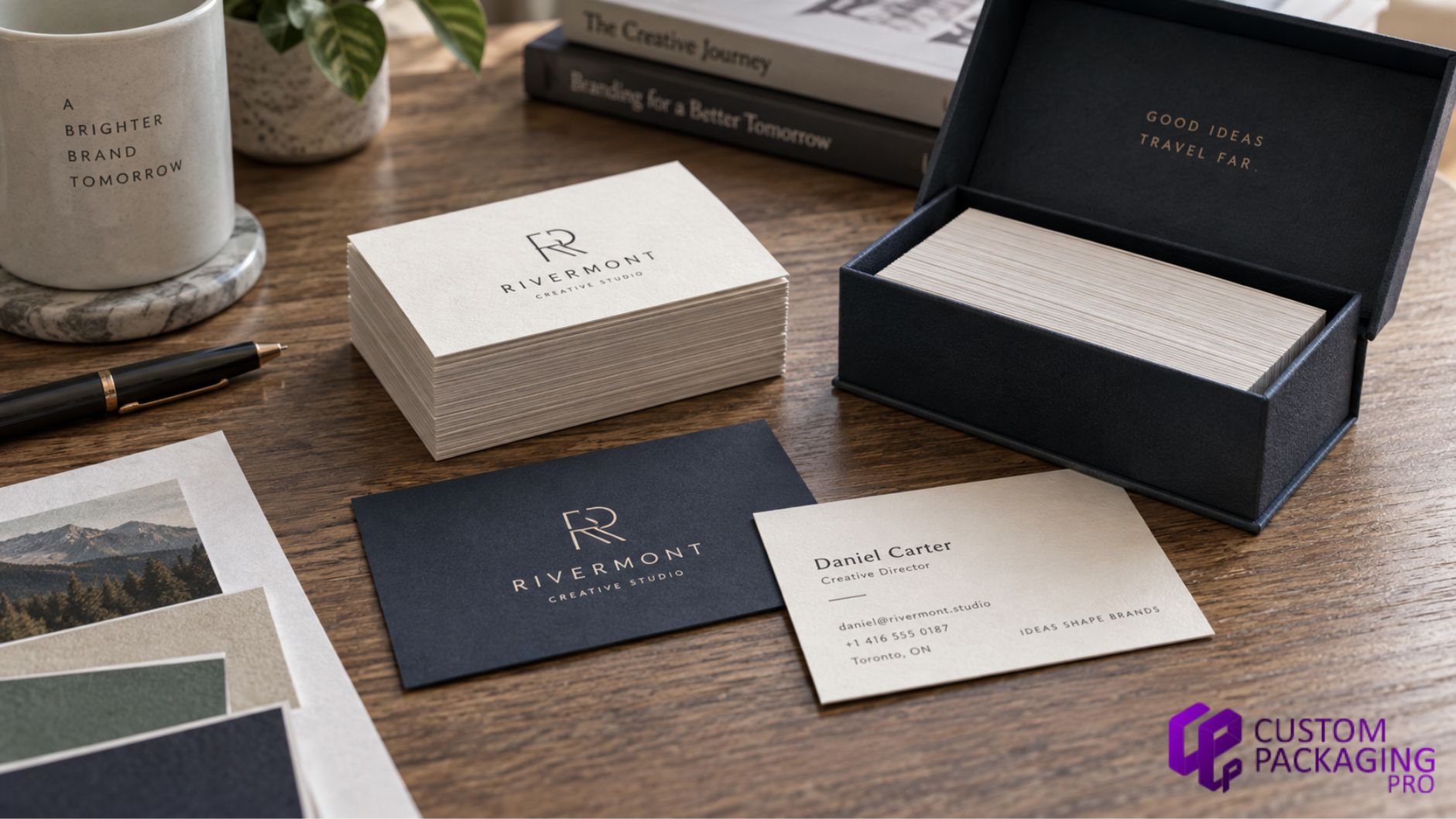 Premium business cards with custom logo printing displayed beside a black business card box on a wooden desk